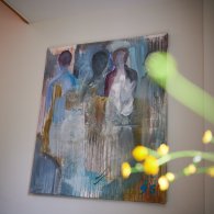 Ein Gemälde hängt an der Wand und verleiht dem Raum eine künstlerische Note und eine warme Atmosphäre.